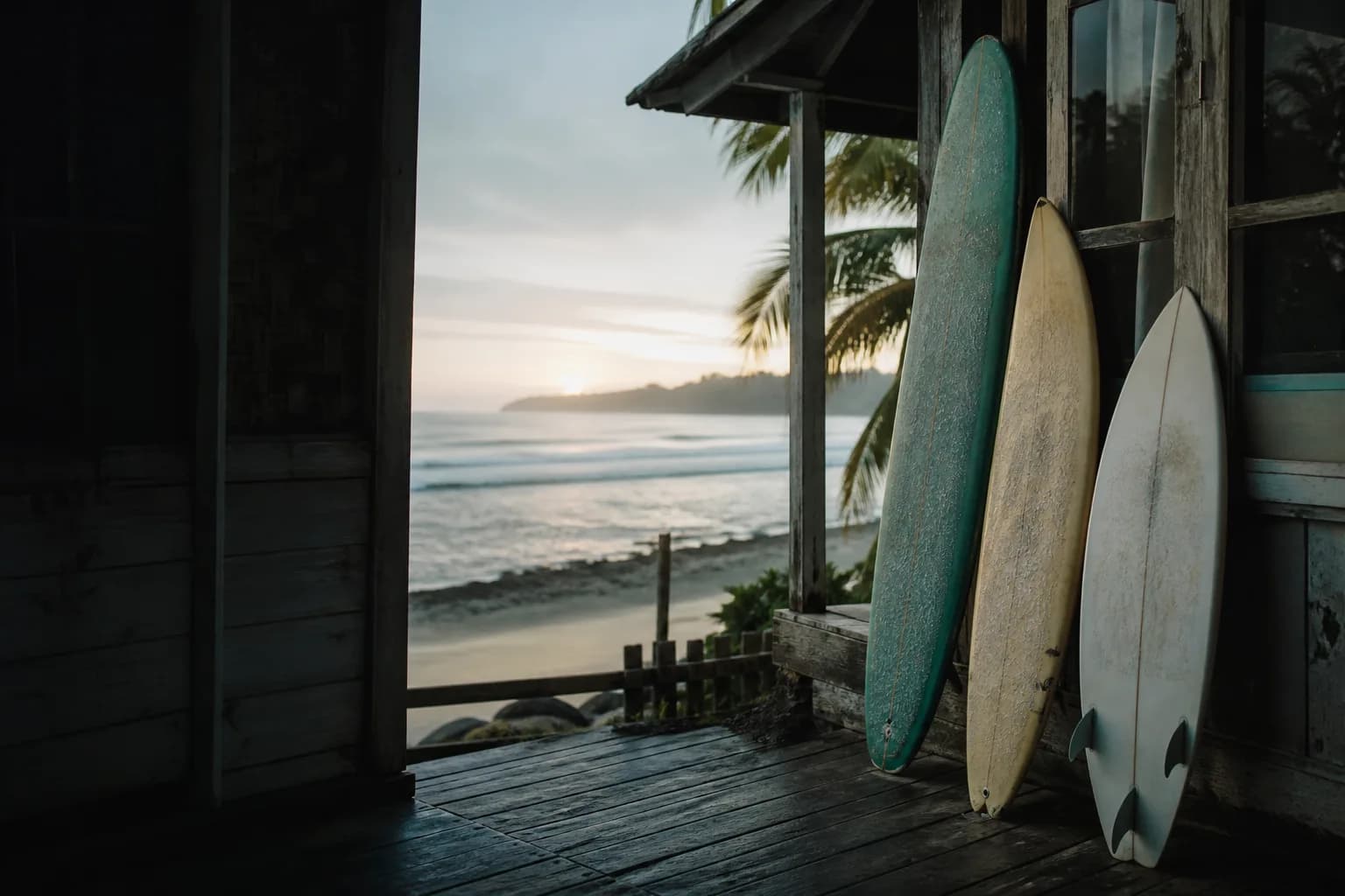 A surfboard quiver resting beside the Indonesian coast at dawn