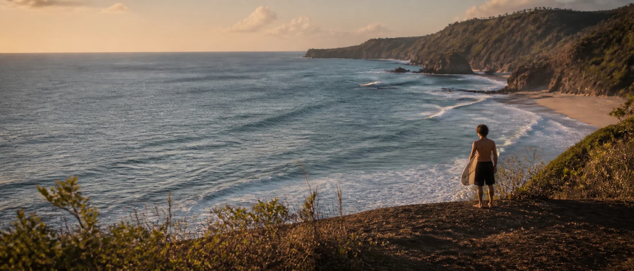 Surfer walking along an Indonesian coastline